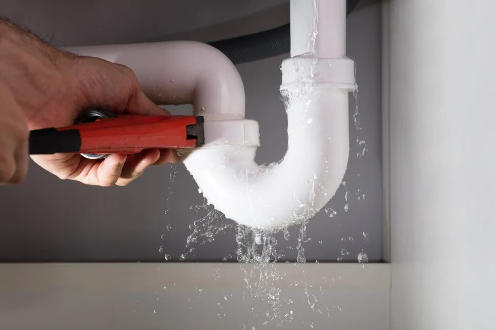 plumber fixing leaking pipe